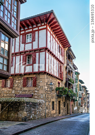 Colorful Buildings, Red Shutters, Flower Balconies, Cobblestone Street, Traditional Architecture in Hondarribia, Spain Colorful Buildings, Red Shutters, Flower Balconies, Cobblestone Street, Traditional Architecture in Hondarribia, Spain 136695310