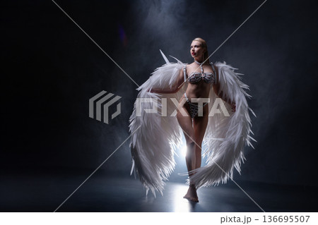 Powerful woman in white angel wings and harness lingerie posing in dramatic smoke Powerful woman in white angel wings and harness lingerie posing in dramatic smoke 136695507