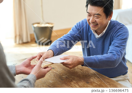 お金を渡すアジア人シニア男性 136696475