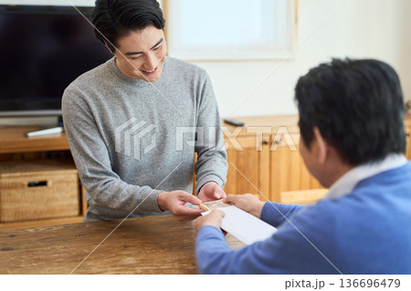 笑顔でお金を受け取るアジア人男性 笑顔でお金を受け取るアジア人男性 136696479