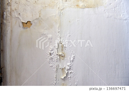 Severe water damage and mold growth on a bathroom ceiling and wall 136697471