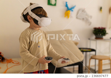Young boy playing a virtual reality game at home Young boy playing a virtual reality game at home 136697477