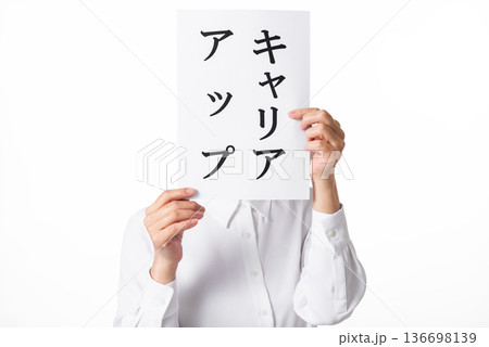 キャリアアップと書かれた紙を両手で持つ白いシャツを着た人物 136698139