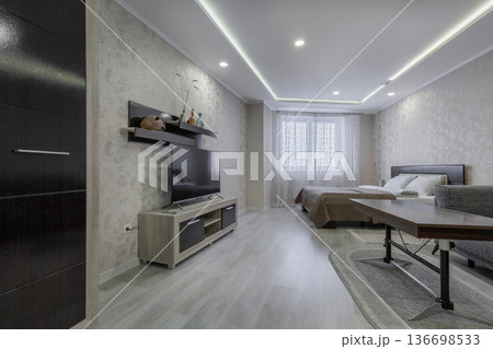 Modern Studio Interior with TV Stand and Minimalist Wardrobe 136698533