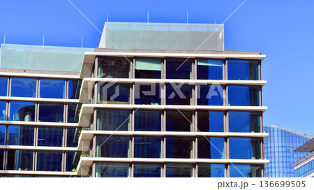 Modern sustainable glass office buildings. Exterior view of corporate headquarters glass buildings architecture.Glass windows in energy-efficient buildings. Financial business center buildings. Modern sustainable glass office buildings. Exterior view of corporate headquarters glass buildings architecture.Glass windows in energy-efficient buildings. Financial business center buildings. 136699505