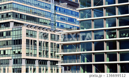 Modern sustainable glass office buildings. Exterior view of corporate headquarters glass buildings architecture.Glass windows in energy-efficient buildings. Financial business center buildings.  136699512