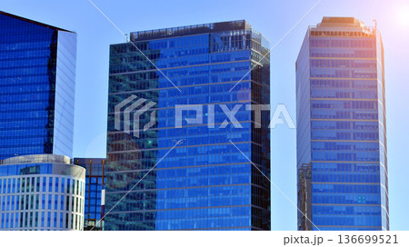 Modern sustainable glass office buildings. Exterior view of corporate headquarters glass buildings architecture.Glass windows in energy-efficient buildings. Financial business center buildings.  136699521