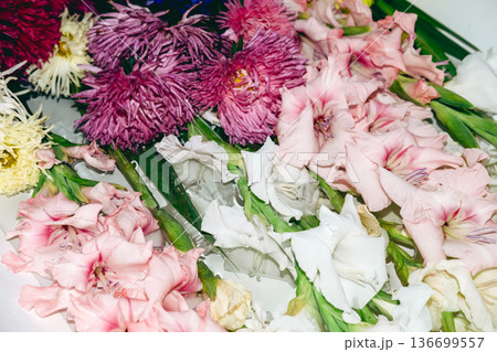Large green leaves and pink flowers soak in white bathtub water. Floral meditation practice, slow arranging flowers, mindful floristry, zen flower therapy. Large green leaves and pink flowers soak in white bathtub water. Floral meditation practice, slow arranging flowers, mindful floristry, zen flower therapy. 136699557