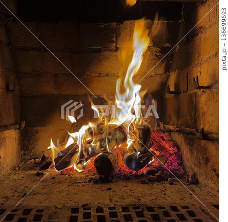 Cozy home fireplace with bright flames and burning logs Cozy home fireplace with bright flames and burning logs 136699693