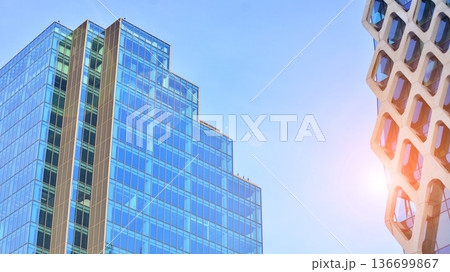 Modern sustainable glass office buildings. Exterior view of corporate headquarters glass buildings architecture.Glass windows in energy-efficient buildings. Financial business center buildings. Modern sustainable glass office buildings. Exterior view of corporate headquarters glass buildings architecture.Glass windows in energy-efficient buildings. Financial business center buildings. 136699867