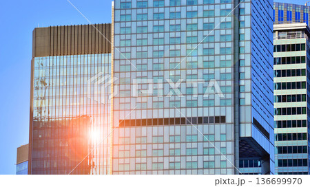 Exterior view of corporate headquarters glass buildings architecture. Modern sustainable glass office buildings. Glass windows in energy-efficient buildings. Financial business center buildings.  136699970