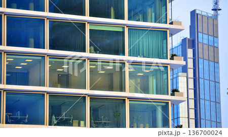 Exterior view of corporate headquarters glass buildings architecture. Modern sustainable glass office buildings. Glass windows in energy-efficient buildings. Financial business center buildings. Exterior view of corporate headquarters glass buildings architecture. Modern sustainable glass office buildings. Glass windows in energy-efficient buildings. Financial business center buildings. 136700024