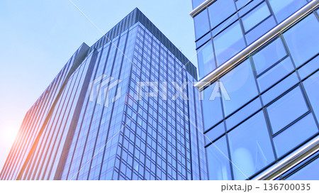 Exterior view of corporate headquarters glass buildings architecture. Modern sustainable glass office buildings. Glass windows in energy-efficient buildings. Financial business center buildings.  136700035