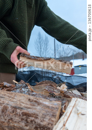 Stacking Firewood Outdoors in Snowy Countryside. Stacking Firewood Outdoors in Snowy Countryside. 136700618