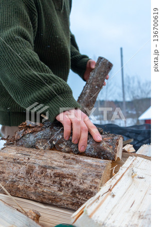 Stacking Firewood Outdoors in Snowy Countryside. Stacking Firewood Outdoors in Snowy Countryside. 136700619