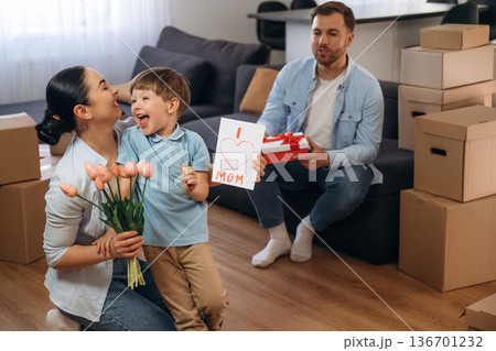 Mother have a birthday, gifts and flowers. Family of husband, wife and son are moving into new house Mother have a birthday, gifts and flowers. Family of husband, wife and son are moving into new house 136701232