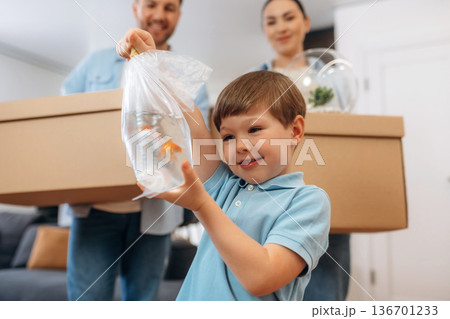 The golden fish in package in water. Family of husband, wife and son are moving into new house The golden fish in package in water. Family of husband, wife and son are moving into new house 136701233