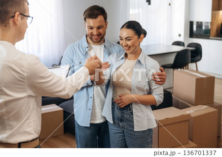 Receiving keys. Couple are buying new house with the help of manager 136701337