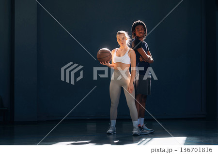 Man and woman are standing together, with basketball ball 136701816