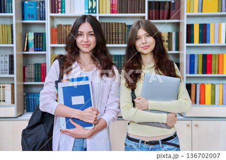 Portrait of two teenage students classmates looking at camera in classroom library Portrait of two teenage students classmates looking at camera in classroom library 136702007