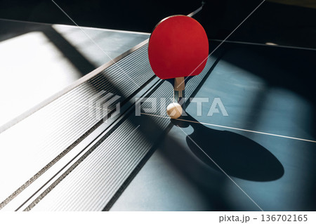 Under sunlight. Racket and ball are on the tennis table indoors Under sunlight. Racket and ball are on the tennis table indoors 136702165