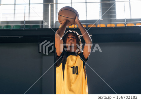 About to throw the ball. Young black man is playing basketball indoors About to throw the ball. Young black man is playing basketball indoors 136702182