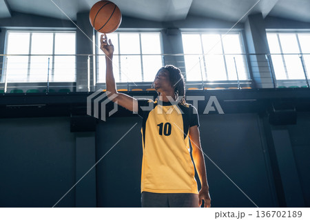 Doing the classic trick. Young black man is playing basketball indoors Doing the classic trick. Young black man is playing basketball indoors 136702189