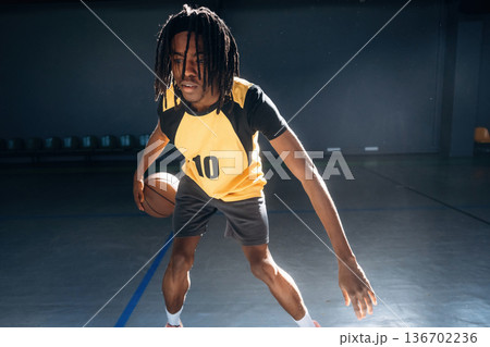 Player number ten. Young black man is playing basketball indoors Player number ten. Young black man is playing basketball indoors 136702236