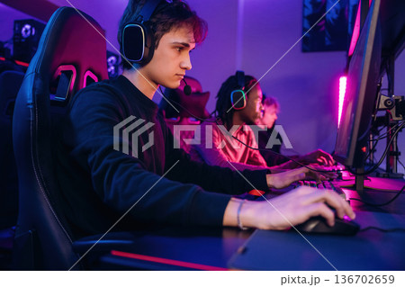 Using keyboard and mouse. Gamers are playing video game by computers Using keyboard and mouse. Gamers are playing video game by computers 136702659