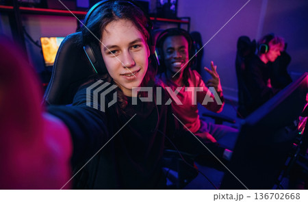 Selfie time. Gamers are playing video game by computers Selfie time. Gamers are playing video game by computers 136702668