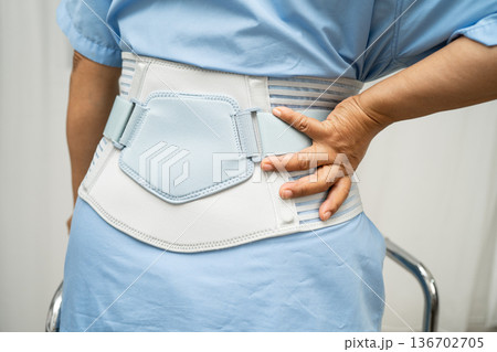 Asian senior pain back wearing elastic support belt with walker. Asian senior pain back wearing elastic support belt with walker. 136702705