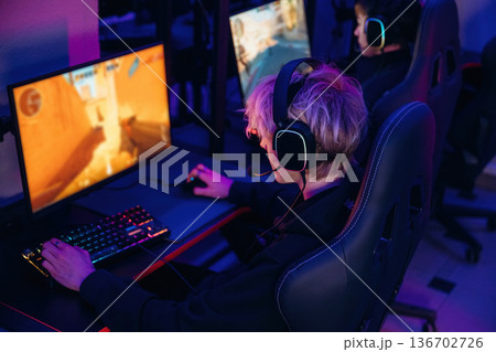 Sitting and focused. Gamers are playing video game by computers Sitting and focused. Gamers are playing video game by computers 136702726
