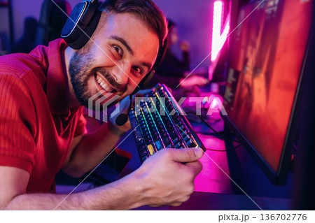Smiling, positive facial expression. Gamers are playing video game by computers 136702776
