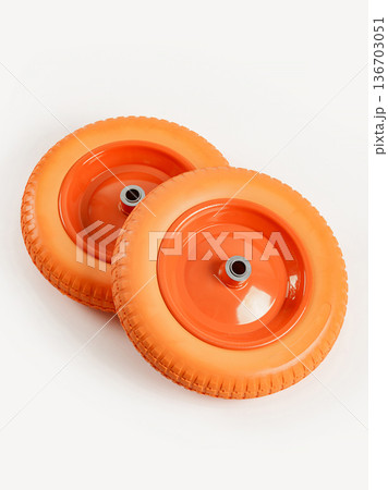 Two wheels from a garden cart on a white background. Orange rubber and disc. 136703051