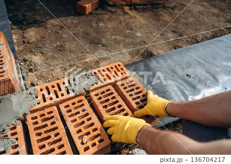 Close up view of construction man that is working with bricks Close up view of construction man that is working with bricks 136704217