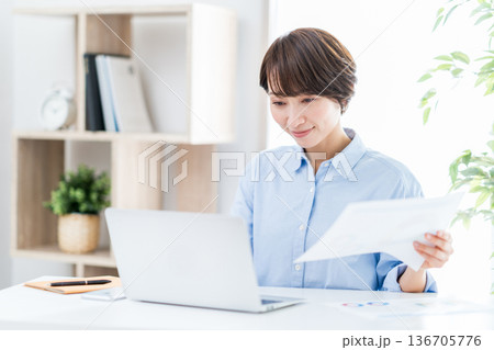 リビングでリモートワークをする女性。 リビングでリモートワークをする女性。 136705776