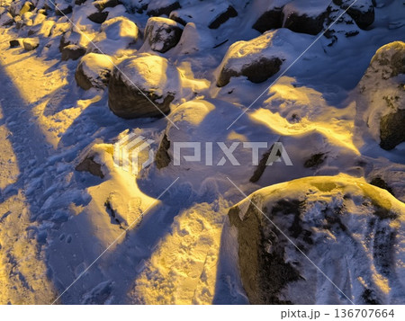 Coastal rocks covered in snow in winter at sunset 136707664