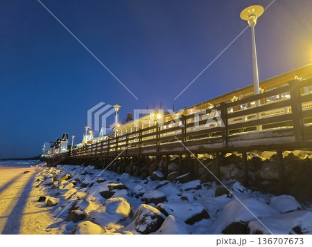 Promenade and coastal cafe as seen from the frozen shore in winter at sunset 136707673