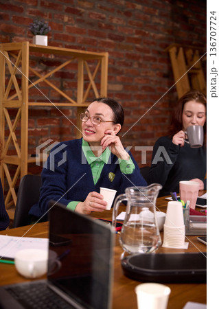 Senior businesswoman listening during team meeting in office. 136707724