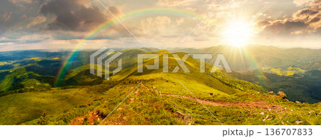 beautiful landscape of mountainous area on a summer sunset. panoramic view of great ridge in dappled evening light. alpine scenery with path through green grass on steep slopes. cloudy weather 136707833
