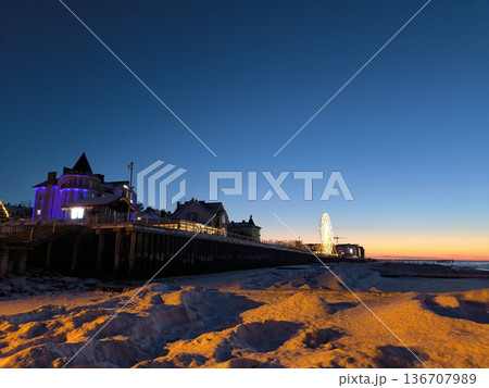 View of a coastal town from the frozen shore in winter at sunset 136707989