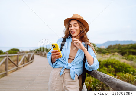 Woman tourist with phone enjoying beautiful views. Europe travel. Lifestyle, nature, active life. 136708097