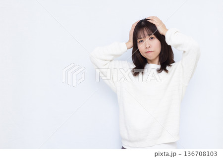 頭を抱えて悩む女性 136708103