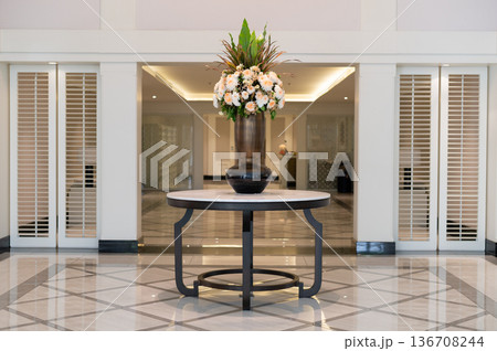 Elegant flower vase on round table in luxury hotel lobby 136708244