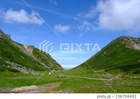 青空の下に広がる高原の山間谷と緑の斜面風景 青空の下に広がる高原の山間谷と緑の斜面風景 136708492