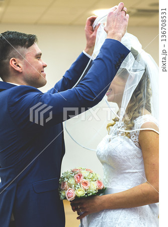 Groom Lifting Bridal Veil During Wedding Ceremony 136708531