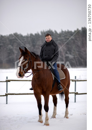 Smiling Groom Riding Horse In Winter Field 136708730