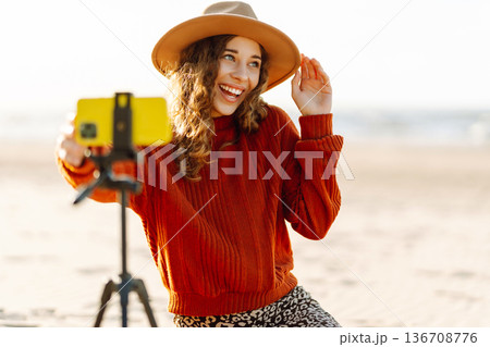 Style woman using smartphone with stabilizer. Travel, blogging, technology concept. 136708776