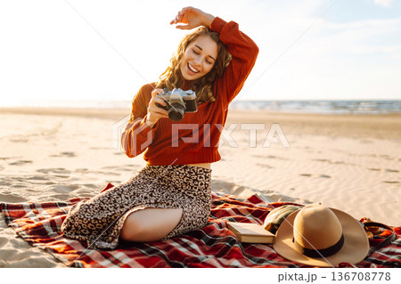 Happy woman with retro camera on the beach. Travel, weekend, relax and lifestyle concept. 136708778