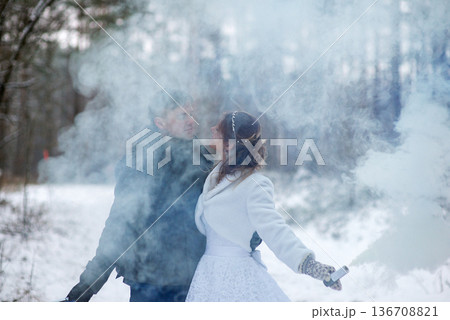 Bride And Groom Surrounded By Soft Smoke In Winter Forest Bride And Groom Surrounded By Soft Smoke In Winter Forest 136708821